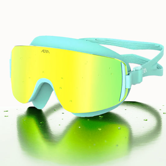 ÆRA Emerald swimming goggles in yellow and green with AERA branding on white background, featuring anti-fog lenses and UV protection for adults