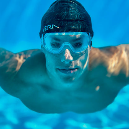 Person wearing a swim cap and clear goggles underwater