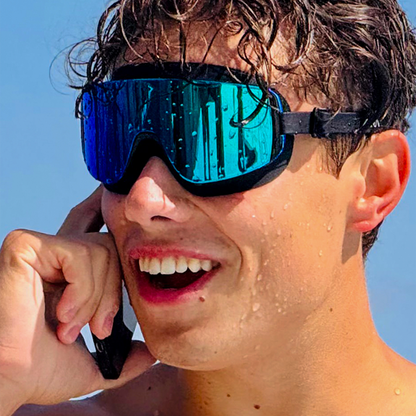 Person wearing blue reflective goggles with a clear blue sky background