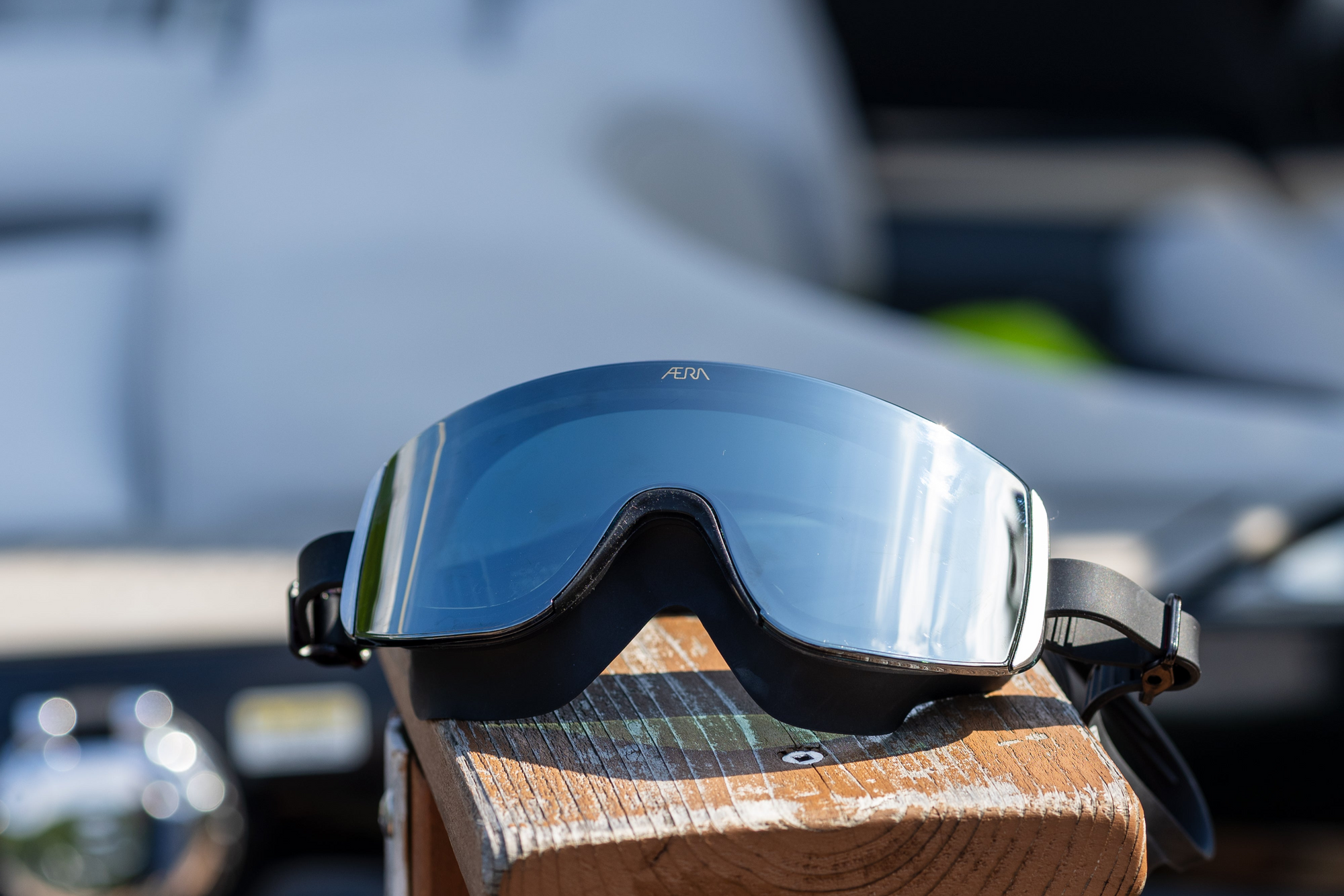 Black goggles on a wooden surface with a blurred background